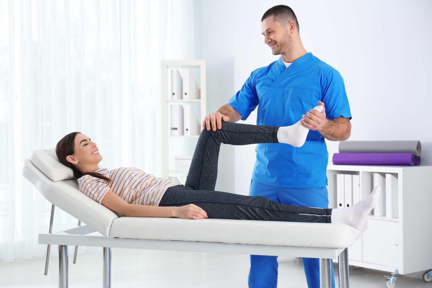 Doctor working with patient in hospital. Rehabilitation physiotherapy ...