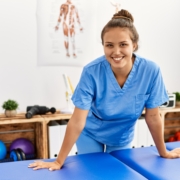 Young beautiful hispanic woman physiotherapist smiling confident standing at rehab clinic